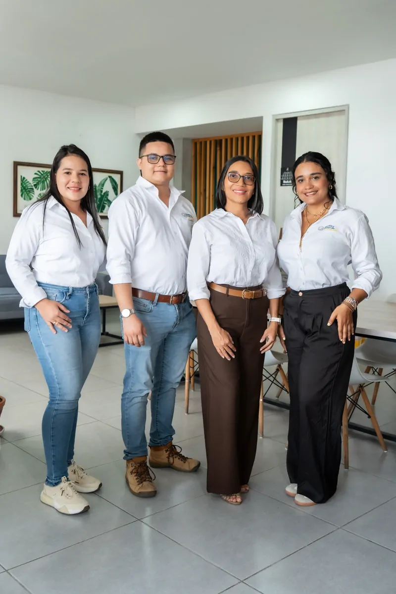 Las cuatro personas del equipo de GDE, de pie en su oficina