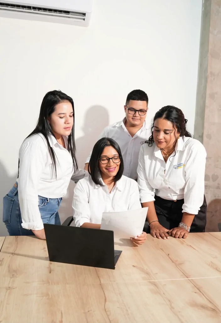 El equipo de GDE revisando un documento alrededor de un portátil