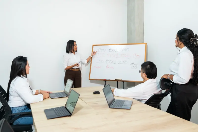 Consultora de GDE explica en el tablero durante una sesión de formación